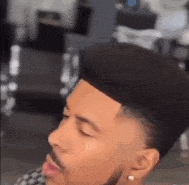 a man with a beard is getting his hair cut by a barber in a barber shop .