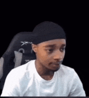 a man is sitting in a chair wearing a headband and a white shirt .