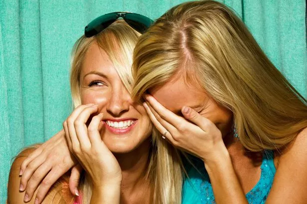 Young-women-laughing-in-photo-booth.jpg