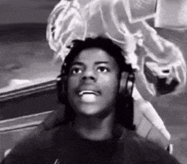 a young man wearing headphones is sitting in a chair looking up .