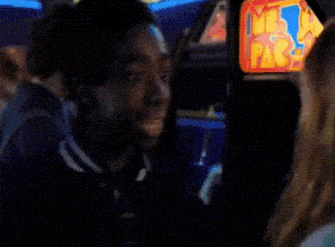 a woman with red hair is playing a video game in an arcade .