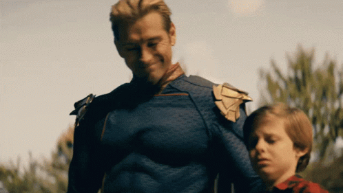 a man in a superhero costume is standing next to a little boy