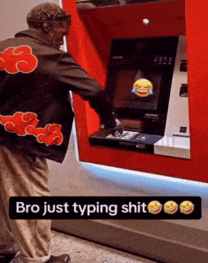 a man wearing a jacket with clouds on it is typing on an atm
