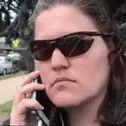 a woman is wearing sunglasses and talking on a cell phone .
