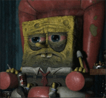 a statue of spongebob is sitting in a chair with a can of coke