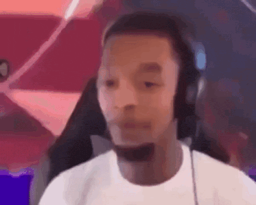 a man wearing headphones and a microphone is making a funny face .