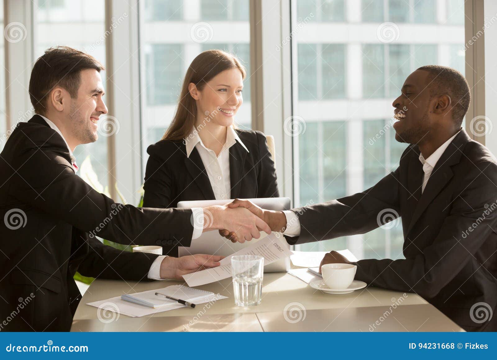 happy-smiling-black-white-businessmen-handshaking-sign-signing-contract-multi-ethnic-meeting-businesswoman-94231668.jpg