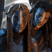 a man and a woman with blue faces are posing for a photo
