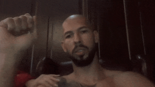 a bald man covering his eyes with his hands
