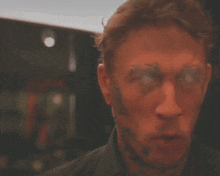a close up of a man 's face with bright red eyes