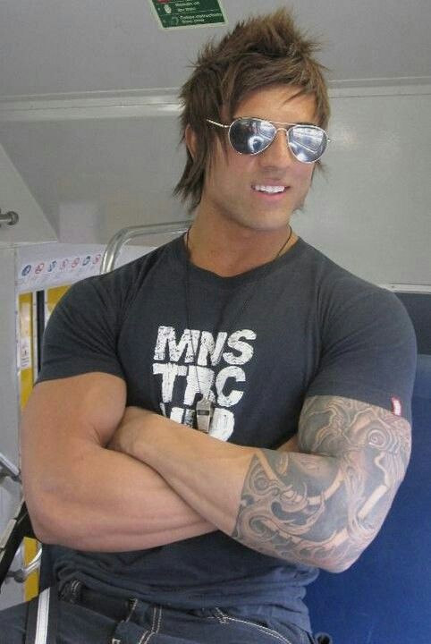 a man with tattoos and sunglasses on his arm posing for a photo in the bus