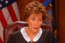 a judge sitting in front of an american flag