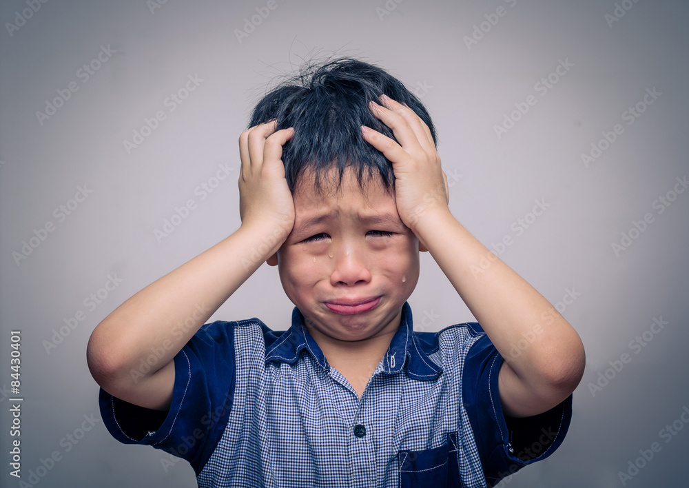 Asian boy crying over dark background фотография Stock | Adobe Stock