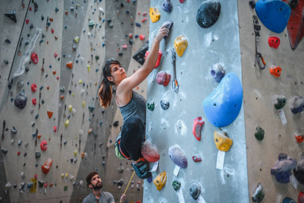 belayer-watching-female-sport-climber-ascending-pillar.jpg