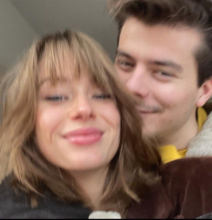 This may contain: a man and woman are smiling for the camera while holding each other's head