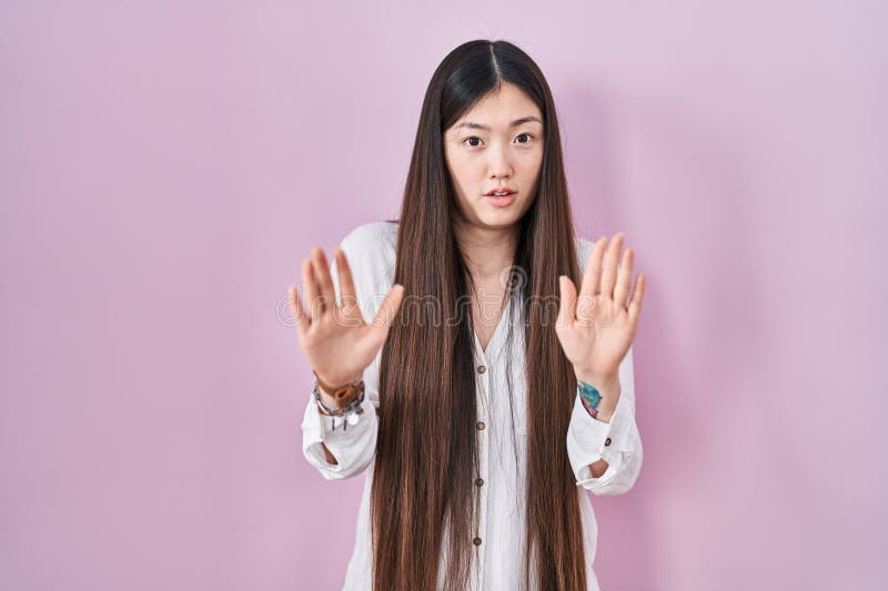 chinese-young-woman-standing-over-pink-background-moving-away-hands-palms-showing-refusal-denial-afraid-disgusting-269714505.jpg