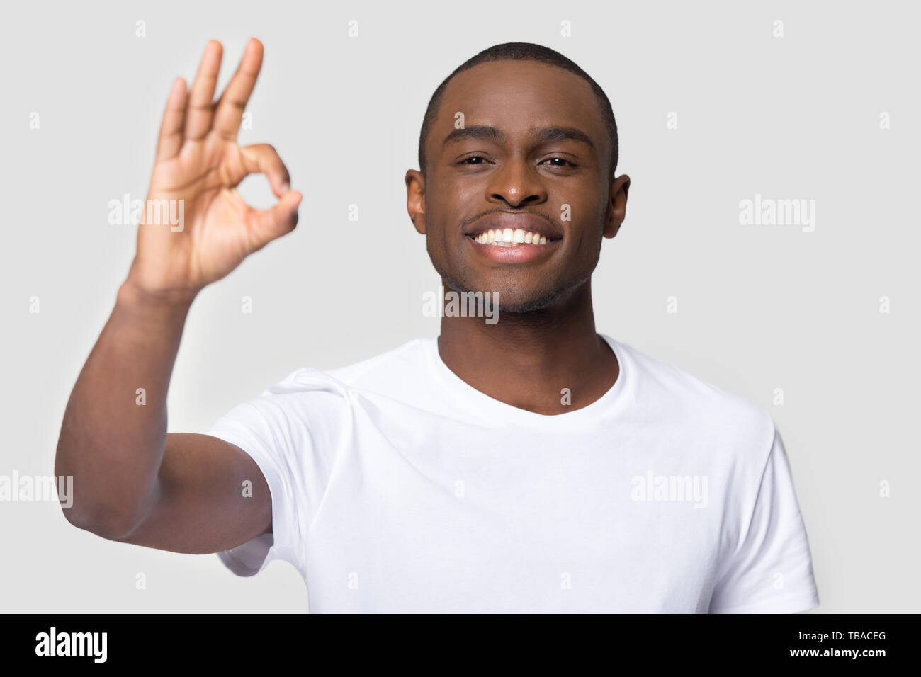 happy-african-male-showing-ok-sign-pose-on-grey-background-TBACEG.jpg