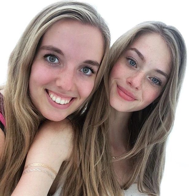 This may contain: two girls are posing for the camera with their arms around each other and one girl is smiling