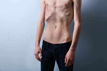 96062409-skinny-young-man-with-anorexia-on-grey-background.jpg