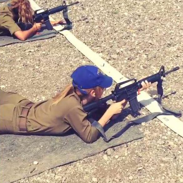  One picture shows the beauty firing an assault rifle