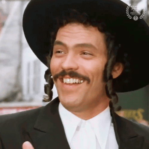 a man wearing a hat and braided hair is smiling for the atlanta international film festival
