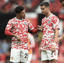 two soccer players wearing red and white jerseys and shorts with the number 25 on them