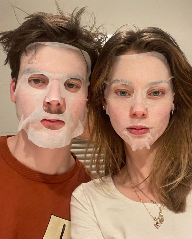 This may contain: two people with facial masks on their faces