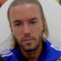 a man with long hair is wearing a blue shirt