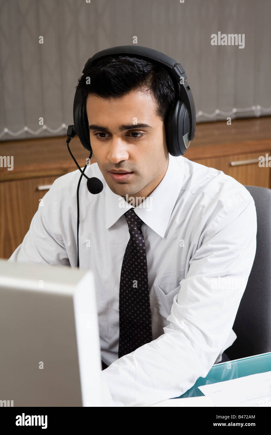 indian-man-working-in-a-call-centre-B472AM.jpg