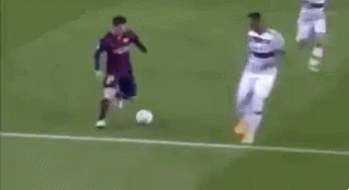 two soccer players are playing a game of soccer on a field . one of the players is falling to the ground .