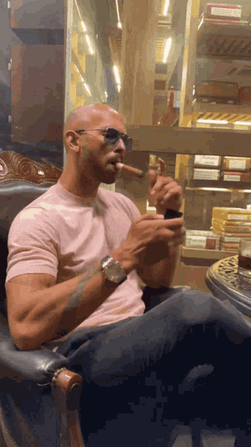 a man wearing sunglasses is smoking a cigar in front of a display case of cigars