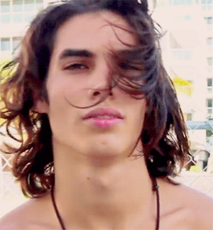 a man with long hair and a necklace around his neck
