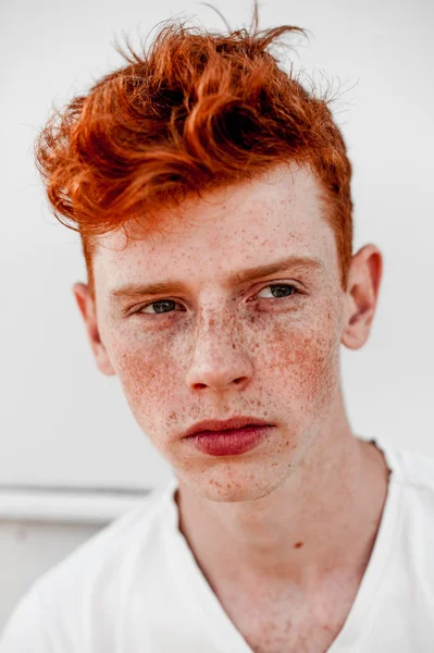 depositphotos_119244876-Portrait-of-attractive-stylish-young-guy-model-with-red-hair-and-freckles-standing-near-white-wall--wearing-white-t-shirt.-Fashionable-outdoor-shot..jpg