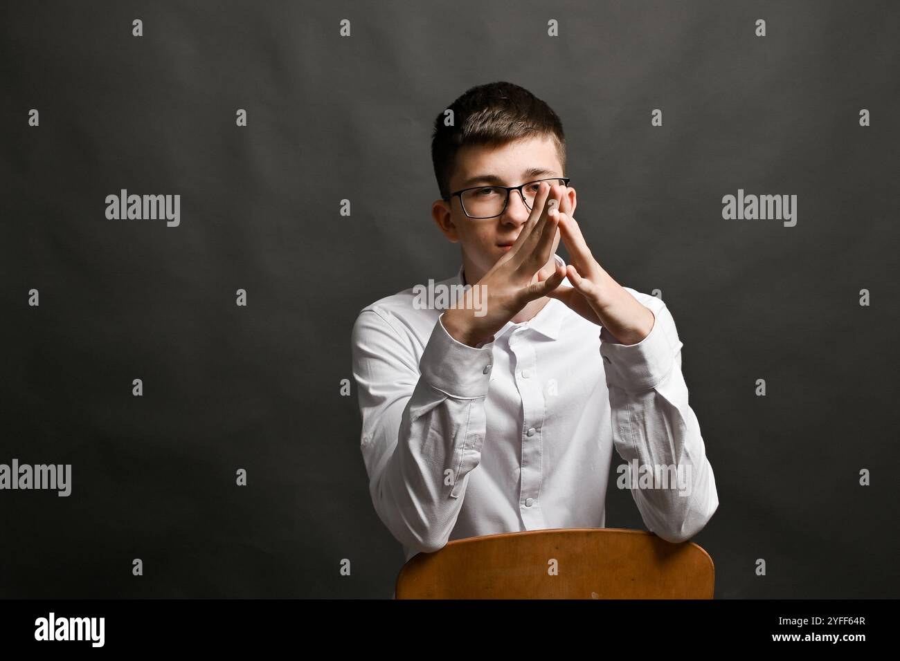 the-young-leader-folded-his-hands-in-a-steeple-gesture-2YFF64R.jpg