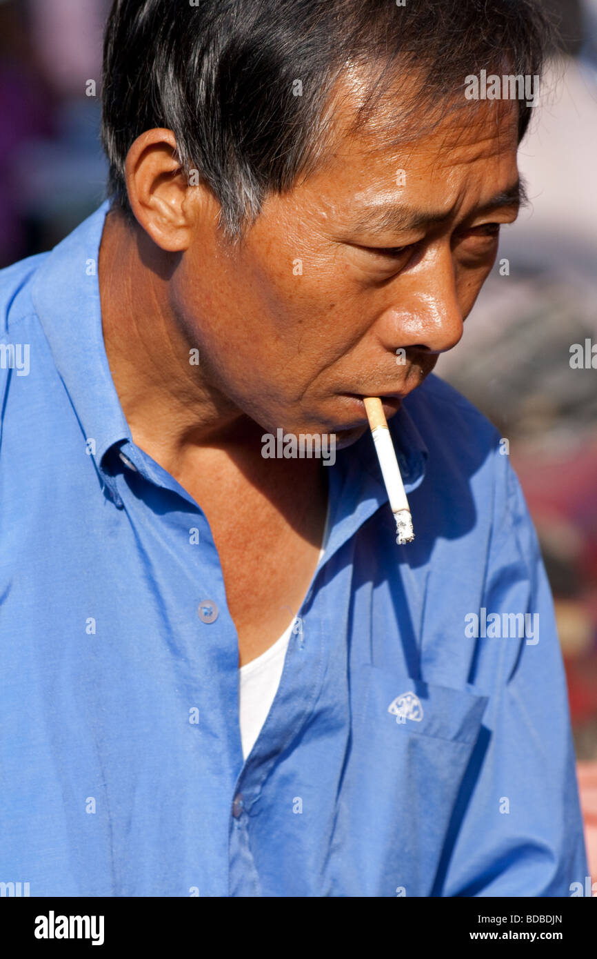 han-chinese-man-smoking-a-cigarrette-in-shipin-town-yunnan-china-BDBDJN.jpg