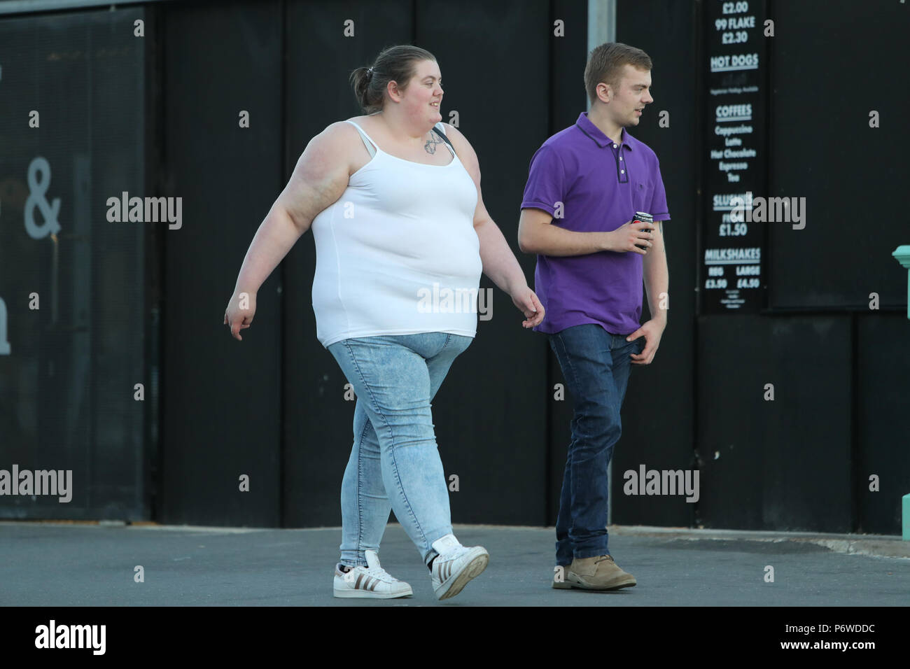 an-overweight-woman-walking-with-a-thin-man-P6WDDC.jpg