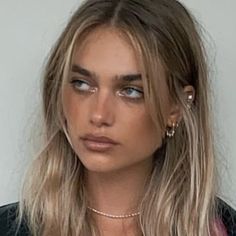 This may contain: a woman with long blonde hair and blue eyes wearing a black blazer, necklace and earrings This may contain: a woman with long blonde hair and blue eyes wearing a black blazer, necklace and earrings