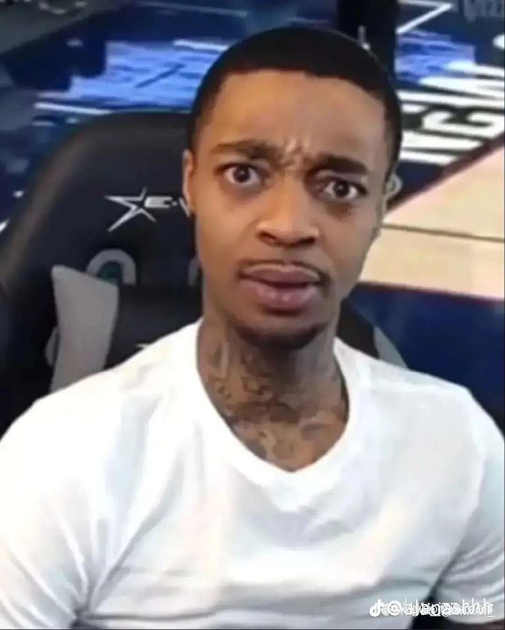 This may contain: a man with tattoos on his face sitting in front of a basketball court This may contain: a man with tattoos on his face sitting in front of a basketball court