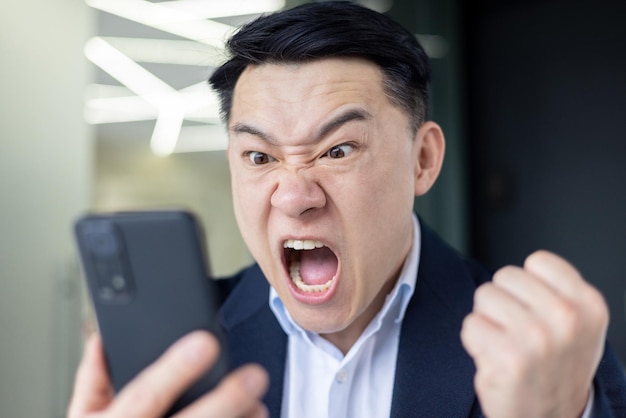 closeup-angry-asian-man-yelling-phone-screen-boss-workplace-unhappy-with-online-trading_321831-17457.jpg