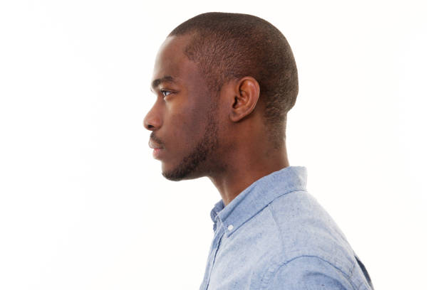 close-up-profile-of-handsome-young-black-man-against-isolated-white-picture-id1142003969