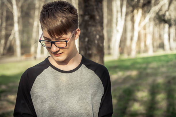 shy-teenager-hipster-boy-in-glasses-outdoors-picture-id696049158