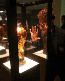 a man looking at a trophy in a glass case with the word cyaneynhu on the bottom a man looking at a trophy in a glass case with the word cyaneynhu on the bottom