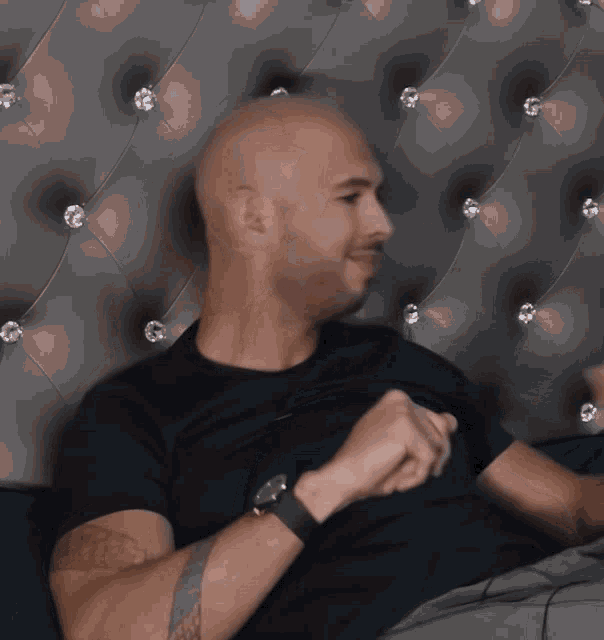 a man in a black shirt is sitting in front of a headboard with rhinestones a man in a black shirt is sitting in front of a headboard with rhinestones