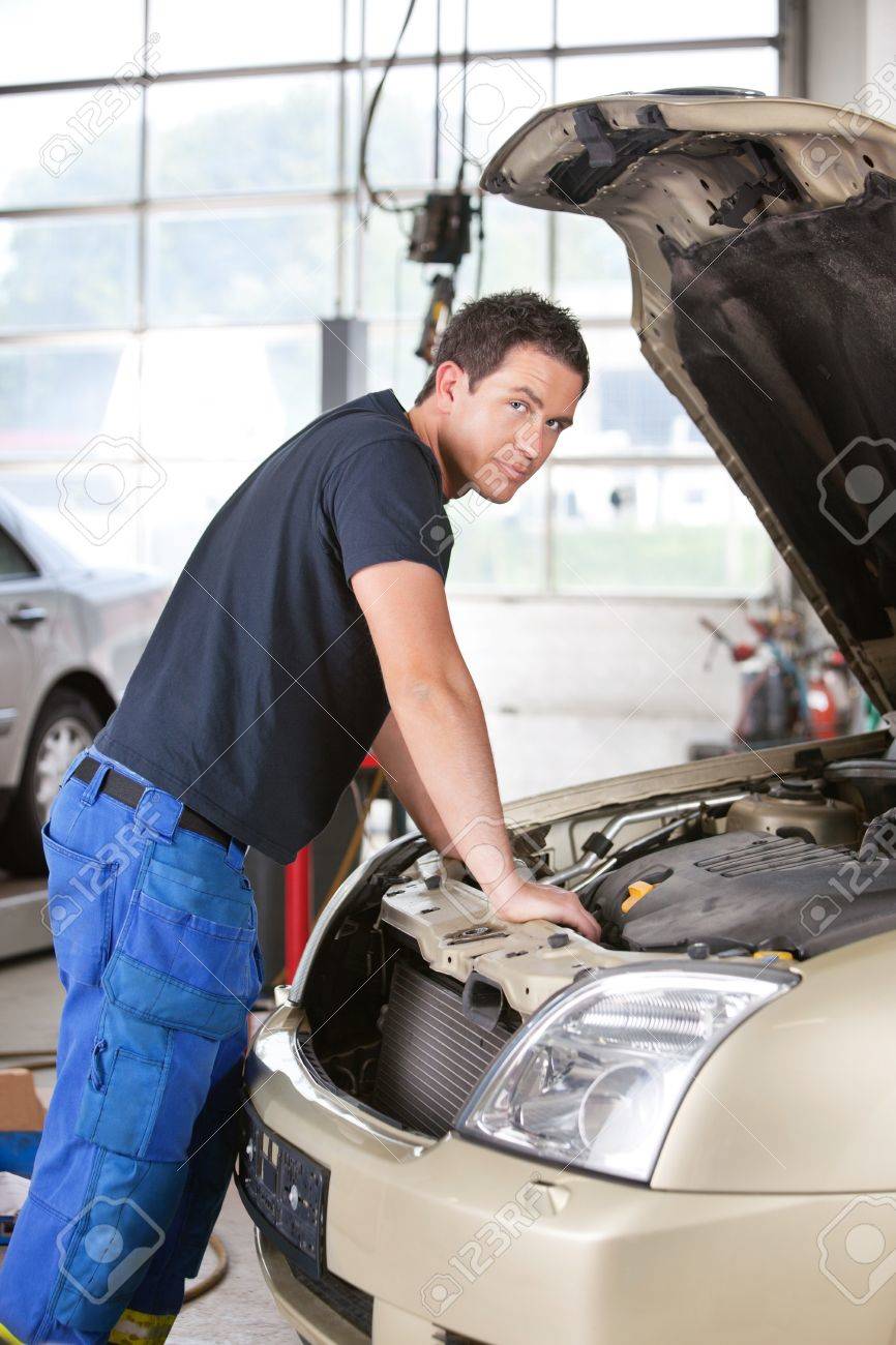10337010-portrait-of-a-mechanic-man-leaning-on-car-in-garage.jpg