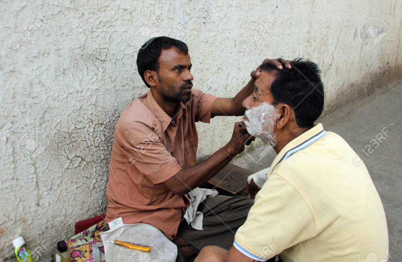 22434052-street-barber-shaving-a-man-using-an-open-razor-blade-on-a-street-in-kolkata-west-bengal-india-on-no.jpg