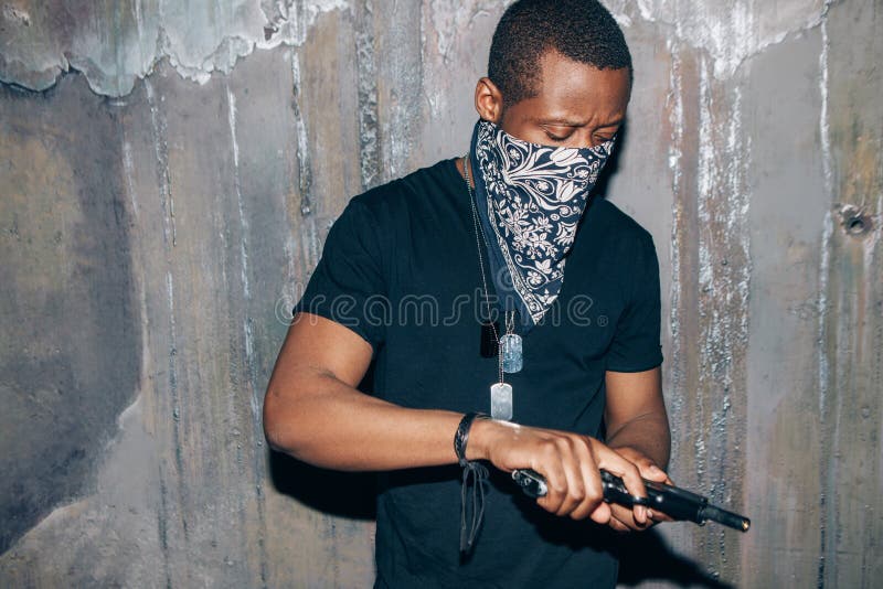 black-gang-member-checks-his-weapon-gangster-man-gun-hand-dark-gray-background-outlaw-ghetto-murderer-armed-attack-94189903.jpg