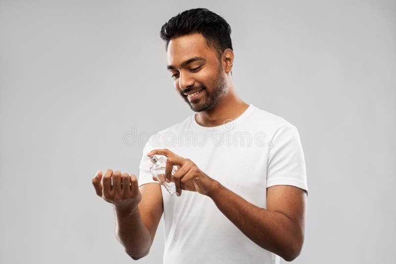 male-perfumery-grooming-people-concept-happy-smiling-young-indian-man-spraying-perfume-to-his-wrist-over-gray-background-130953804.jpg