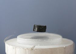 A magnet levitating over a superconducting material. A magnet levitating over a superconducting material.