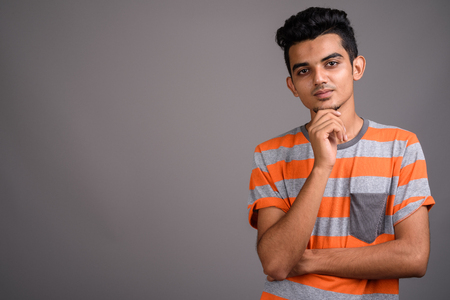 102014731-young-indian-man-against-gray-background.jpg