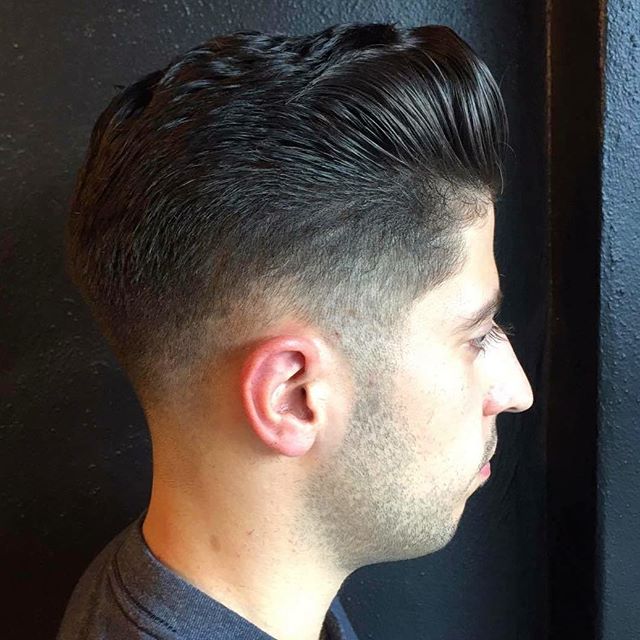 A-barbershop-photograph-of-a-young-Arab-guy-with-a-freshly-cut-pompadour-hairstyle-with-a-short-taper-haircut.jpg